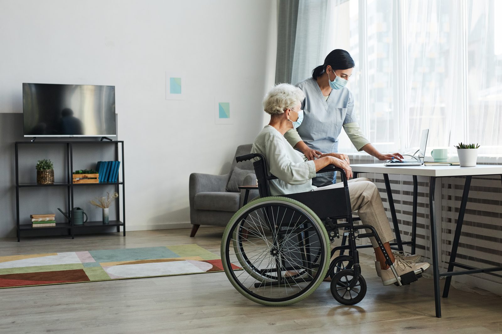 Caregiver assisting an older adult in a warm home environment