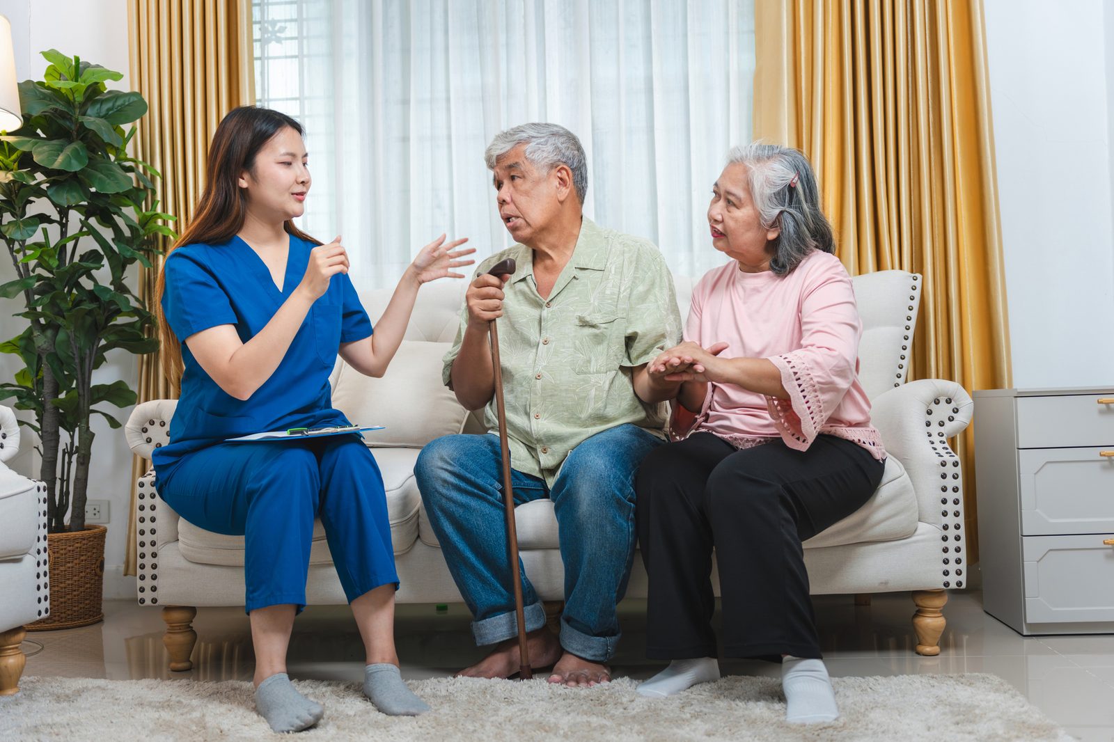 Caregiver talking with an older couple at home