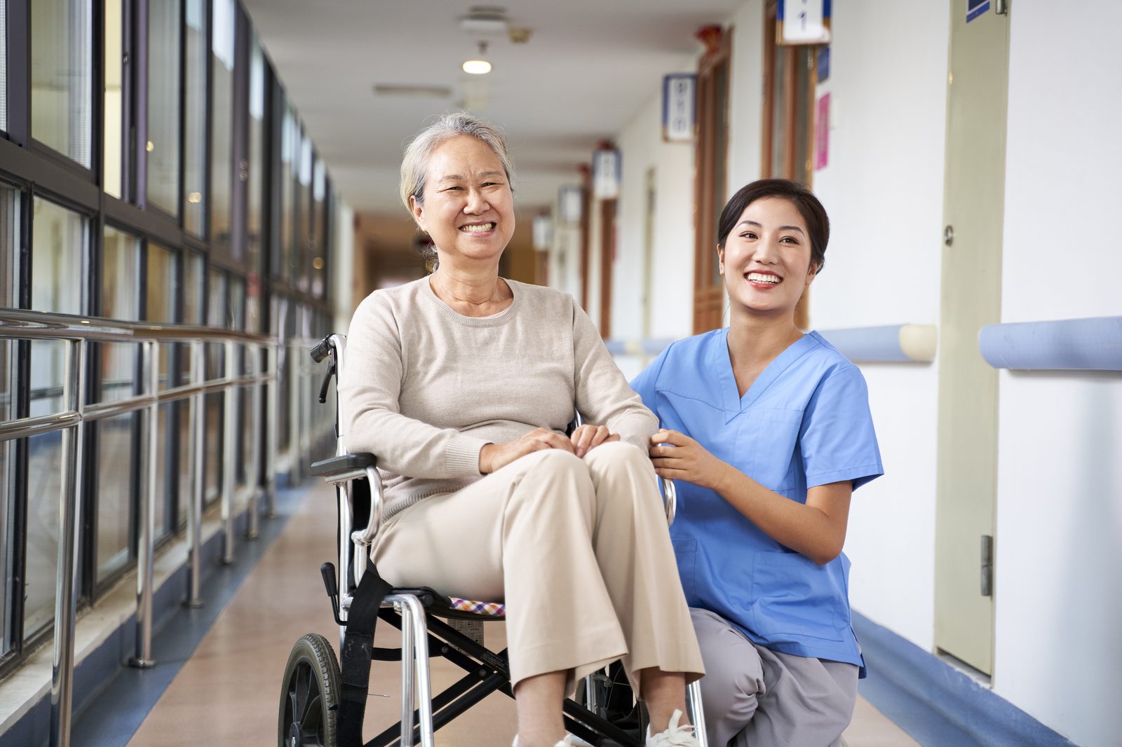 Caregiver and older adult walking together indoors