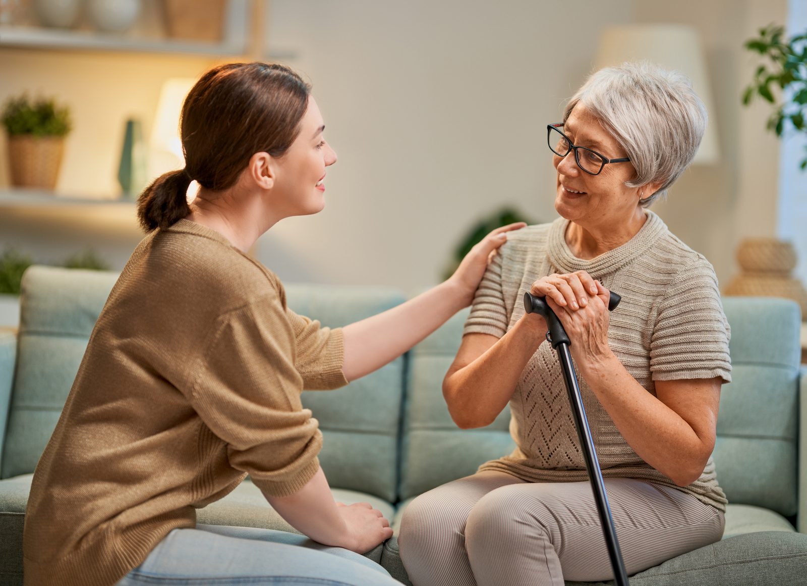 Caregiver and older adult in a warm conversation at home